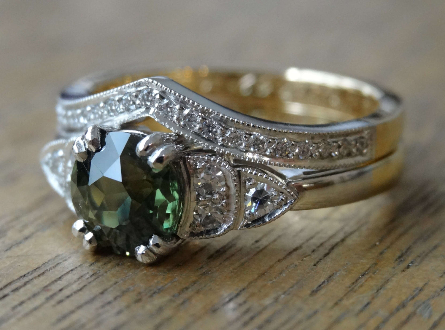 An antique, green sapphire set in an art deco inspired engagement ring with a fitted wedding ring