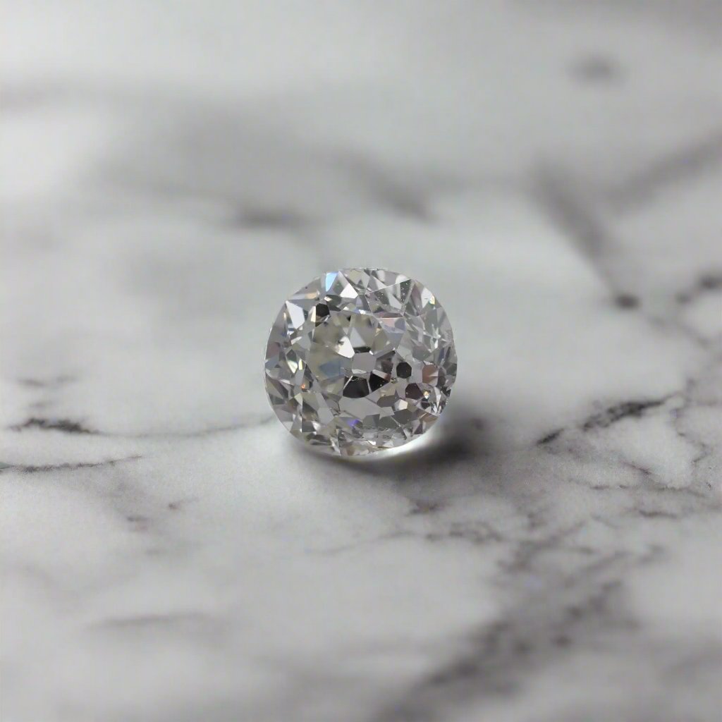 an antique diamond with uneven facets rests on marble