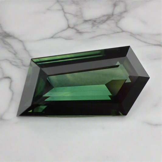 Freeform green gemstone on a marble background