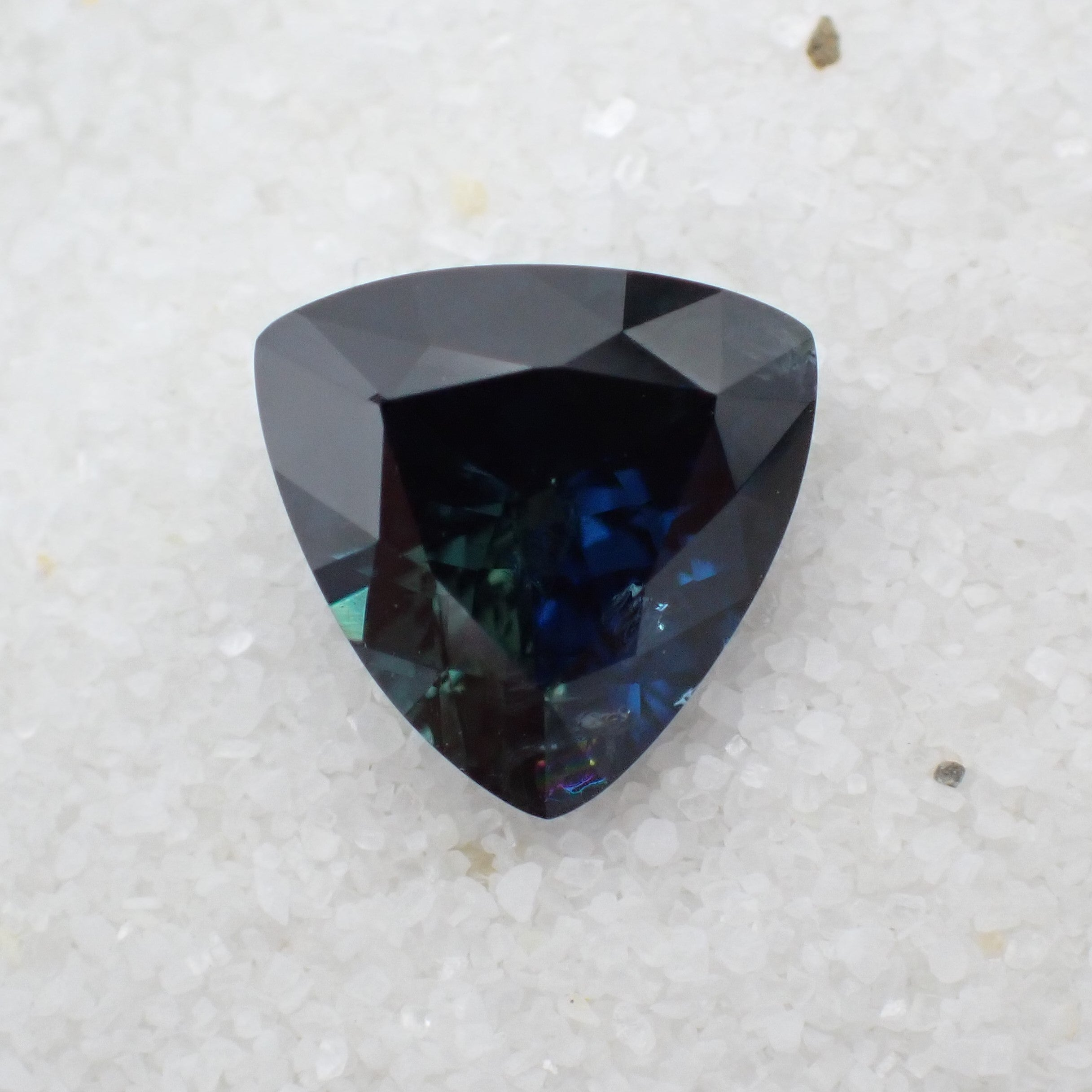 A triangle parti sapphire shows visible but stable inclusions.