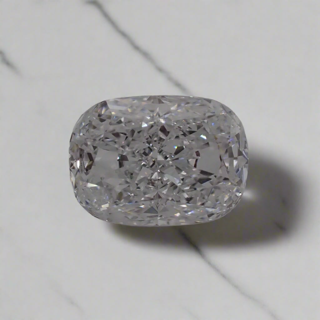 a cushion cut diamond rests on a white surface