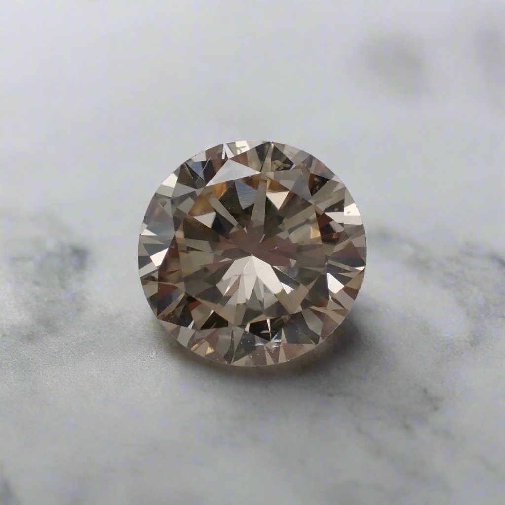 A light champagne diamond, round brilliant cut, rests on a white surface.