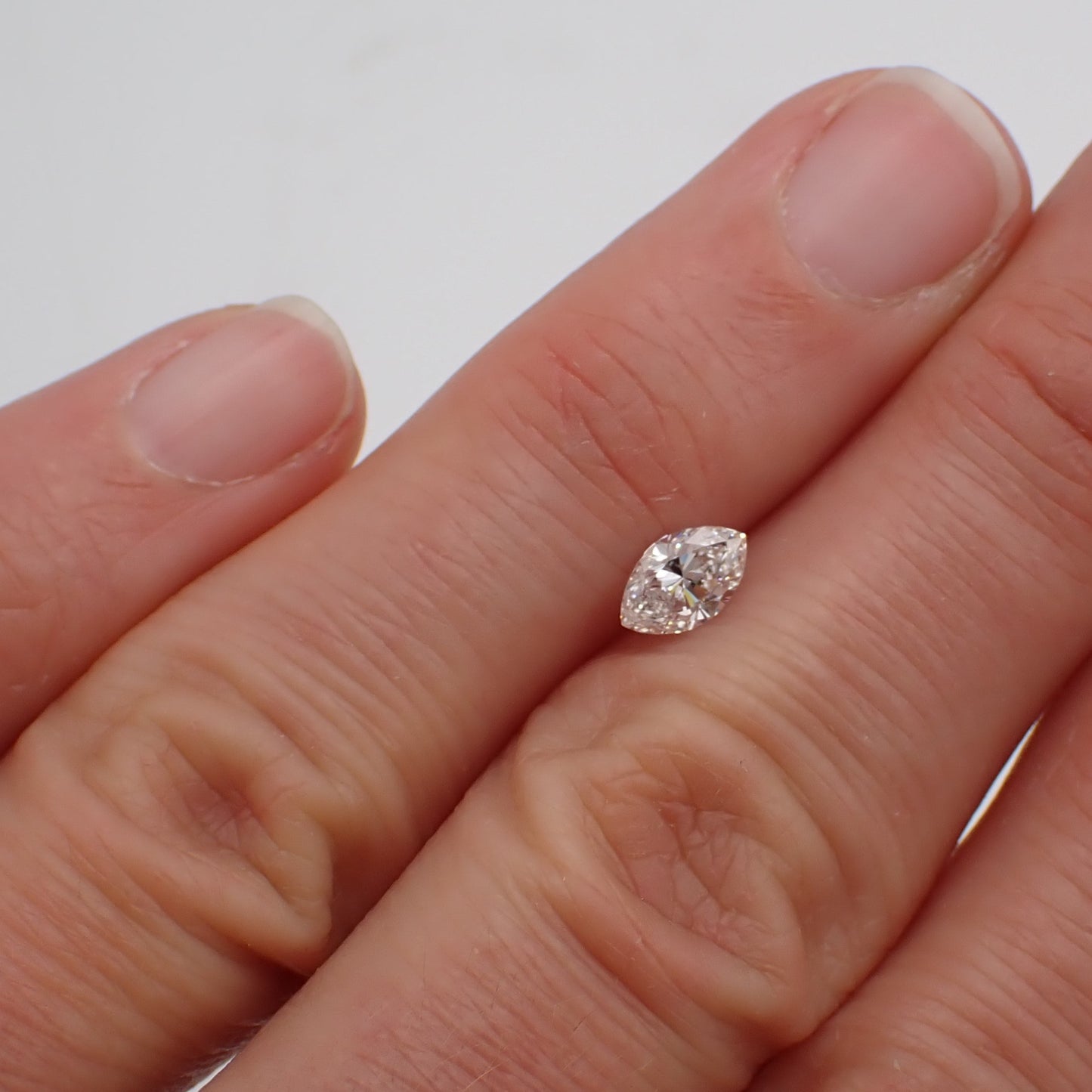 a recycled marquise cut diamond rests between two fingers