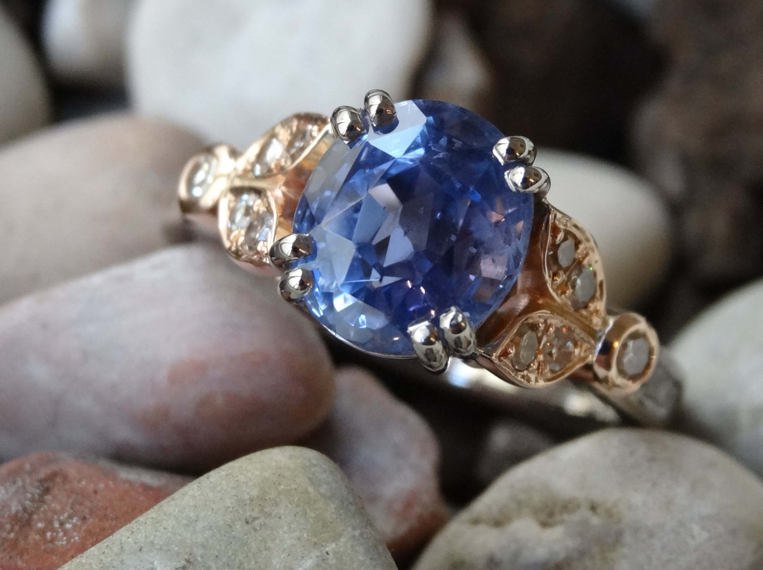 A re-cut sapphire is double claw set in white gold with rose gold and diamond shoulders